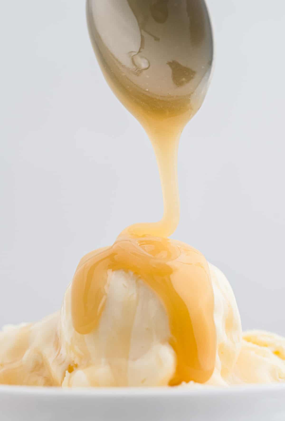 Caramel étant versé sur de la glace à la vanille.