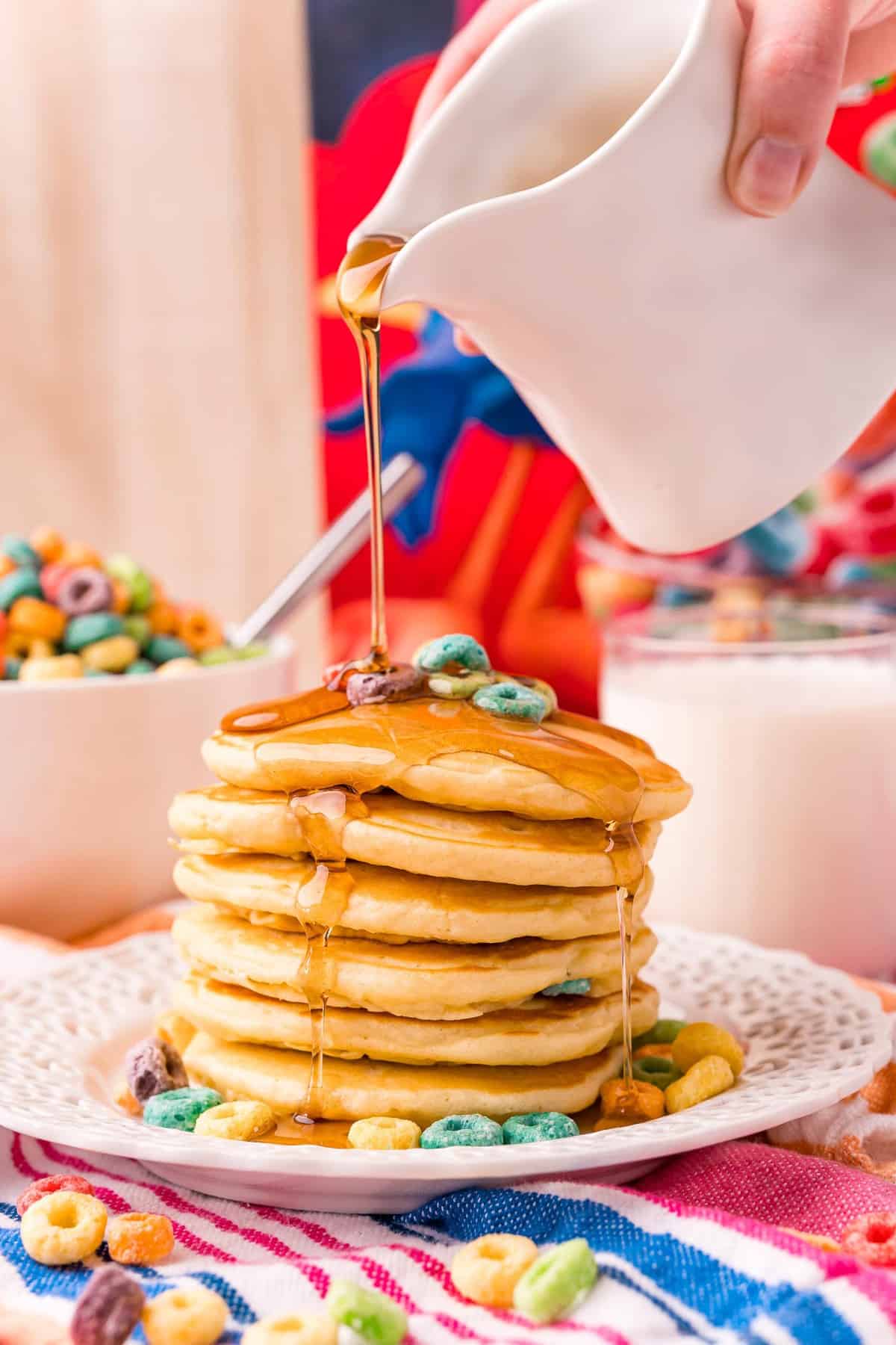 Sirop versé sur une haute pile de pancakes aux Froot Loops.