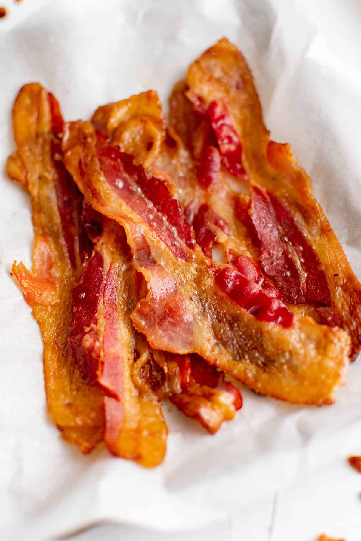 Bacon empilé sur une assiette tapissée de serviettes en papier.
