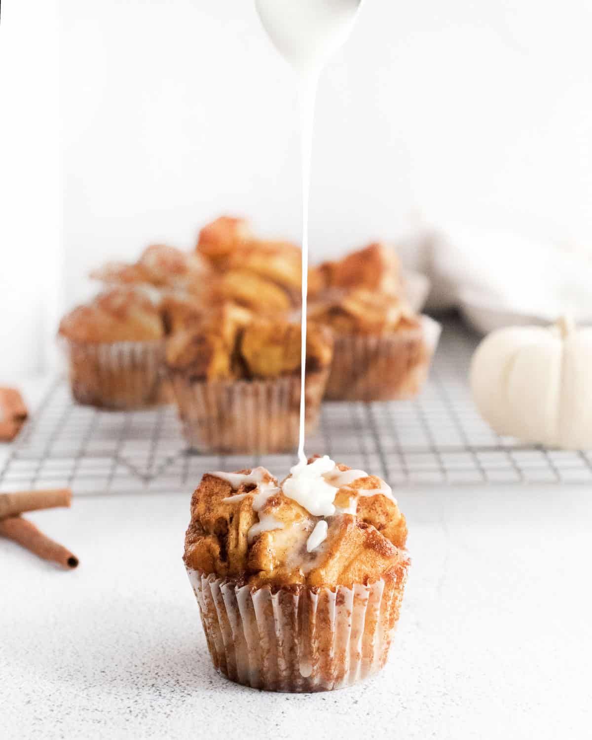 Un muffin de pain de singe à la citrouille arrosé de glaçage.