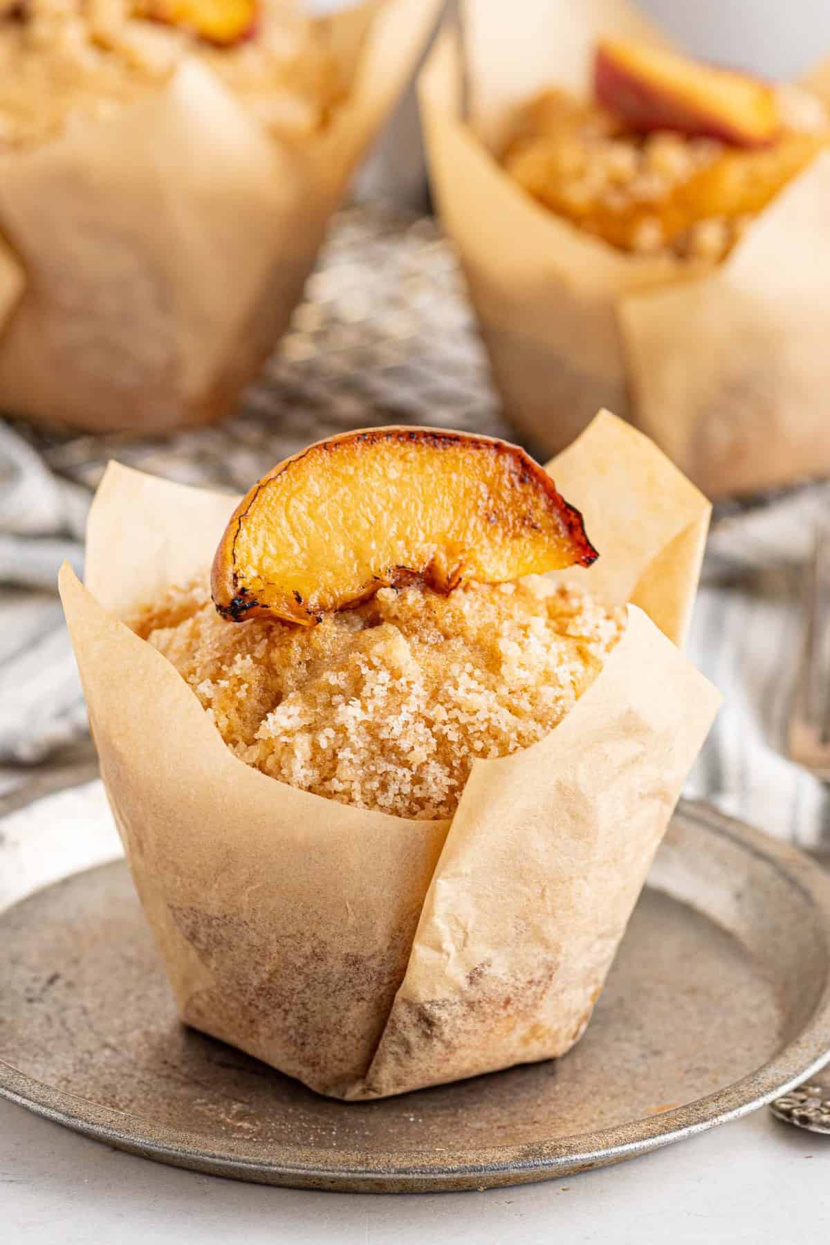 Muffin aux pêches avec du papier sulfurisé.