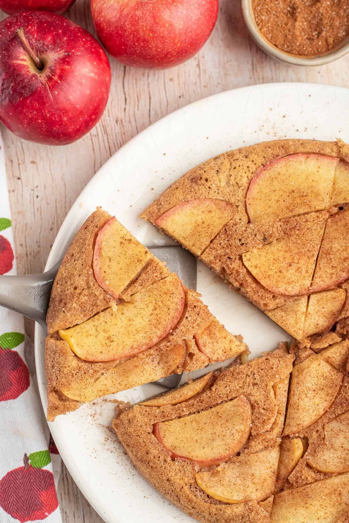 Tranche de pancake aux pommes retirée d'un plateau avec des tranches supplémentaires.