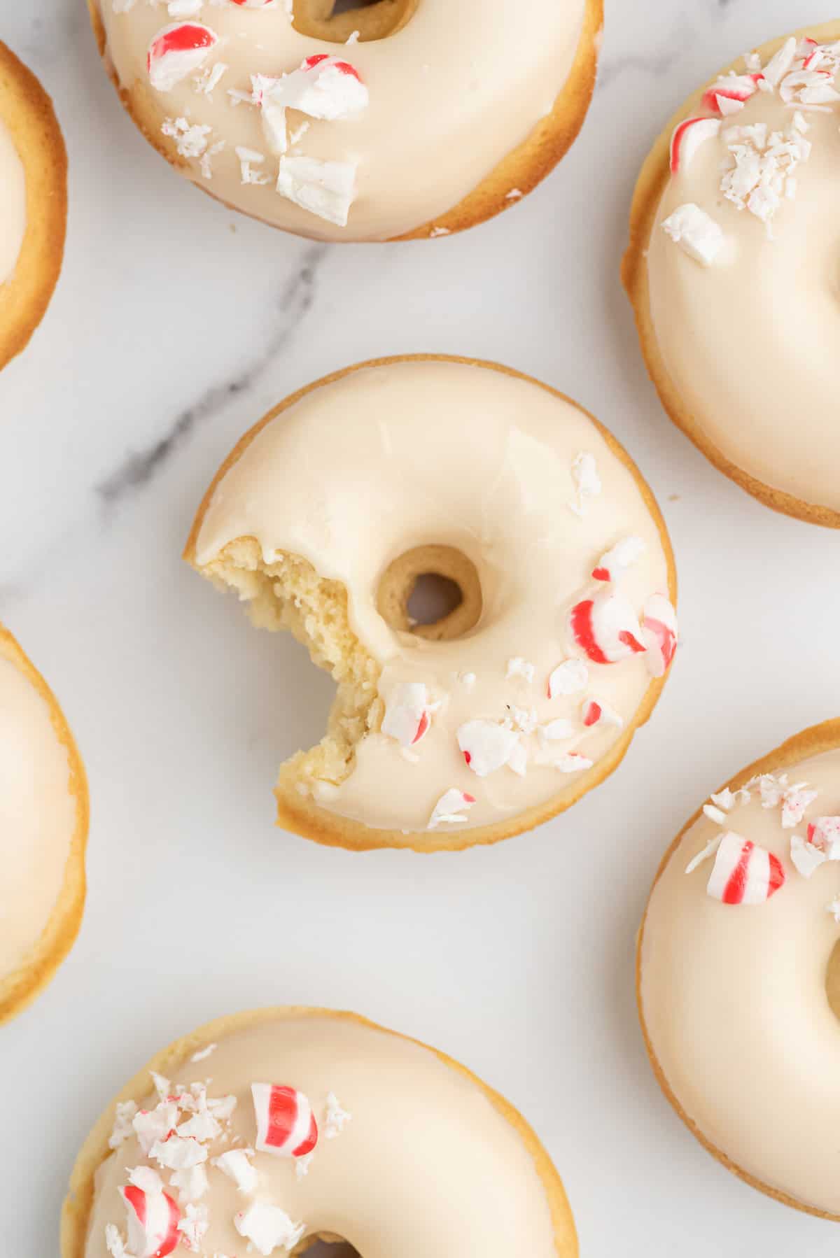 Donuts à la menthe poivrée, l'un d'eux ayant une bouchée enlevée.