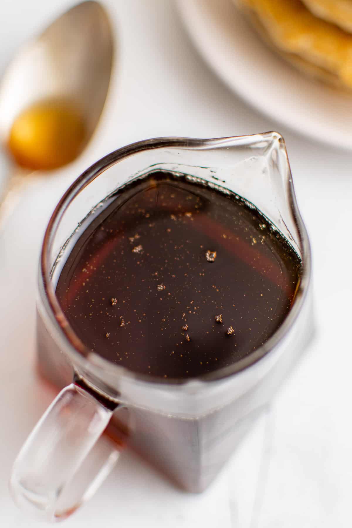 Sirop épais et sombre dans une petite carafe en verre transparent.