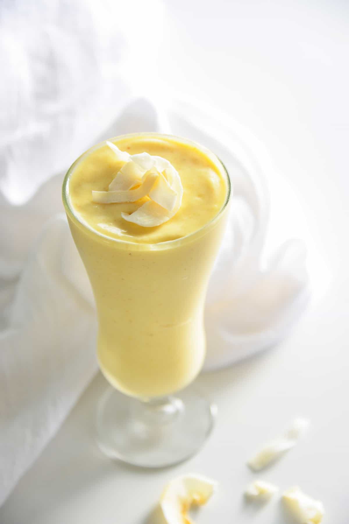 Smoothie mangue-ananas garni de noix de coco.